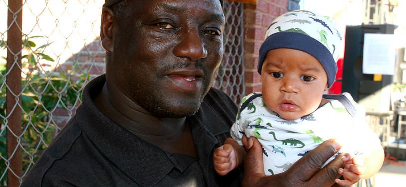 ELAINE. James White lovingly holds a baby outside of his store, The Spot on Main Street at the Elaine Listening Party. 